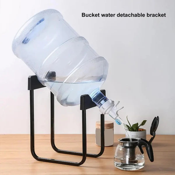 Bucket water detachable bracket pouring water into a glass container on a wooden surface.