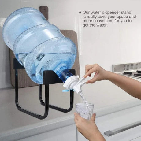 Water dispenser stand with a large water bottle and a person pouring water into a glass.