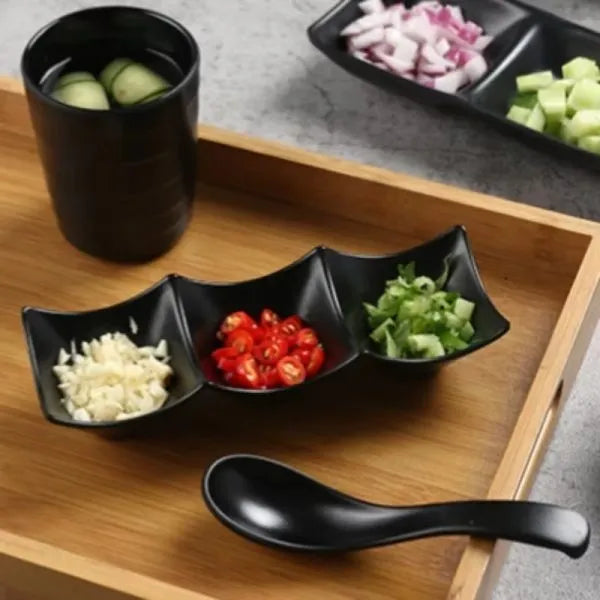 Black divided bowl with ingredients on a wooden tray