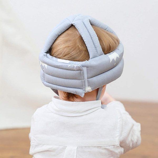 Child wearing a gray headband with straps on a neutral background