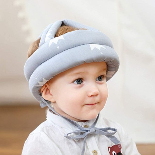Baby wearing a gray head shaping device with a blurred background