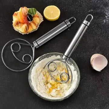 Metallic kitchen tool with a handle on a dark surface with food items.