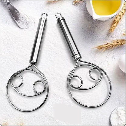 Two metal kitchen tools on a light background with a small bowl of oil and wheat stalks.