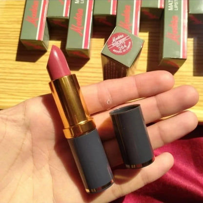 Pink lipstick held in a hand with red boxes in the background