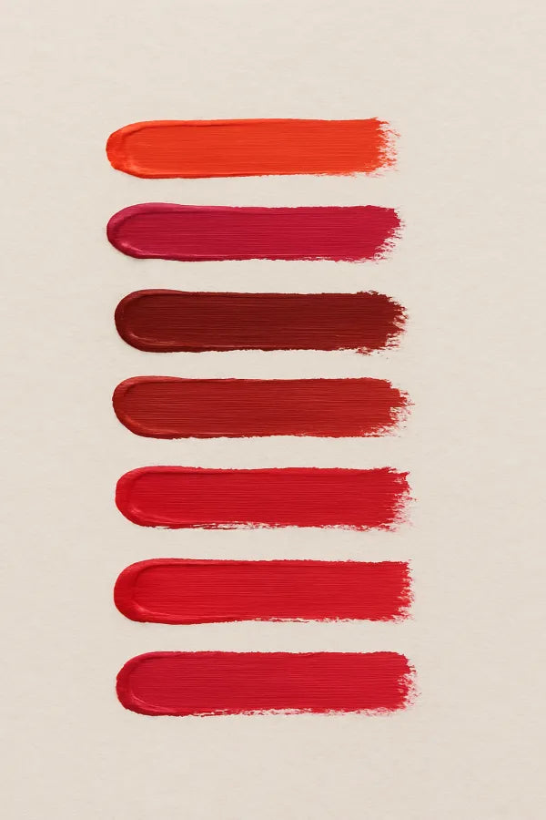 Set of red lipstick swatches on a beige background
