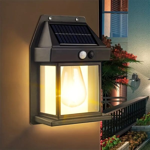 Solar-powered outdoor wall light fixture with warm glow on a wall.