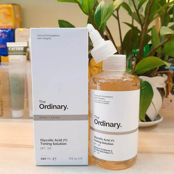 The Ordinary skincare product on a wooden surface with a plant in the background